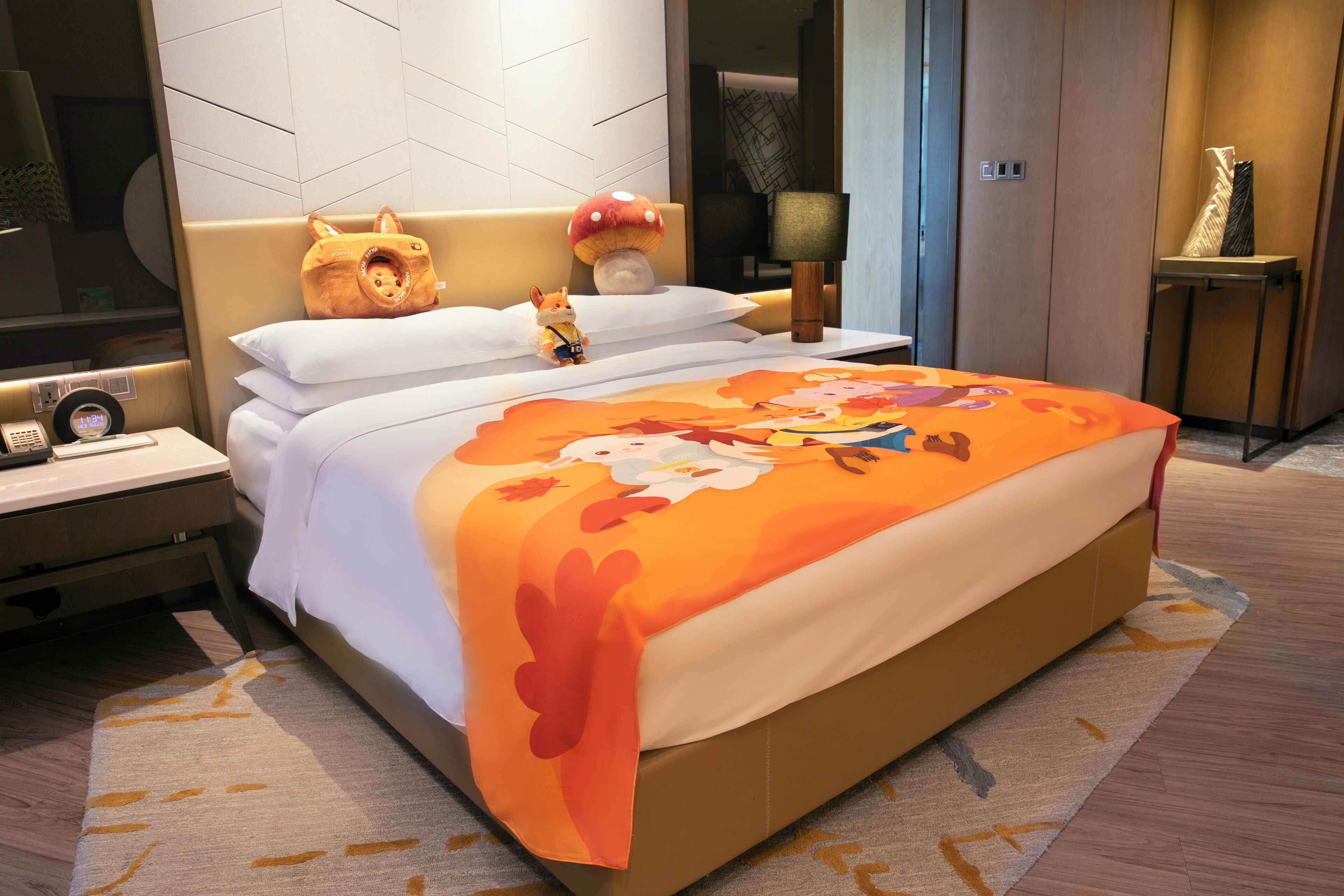Een hotelkamer met een bed, een nachtkastje, een lamp en een wandplank.
