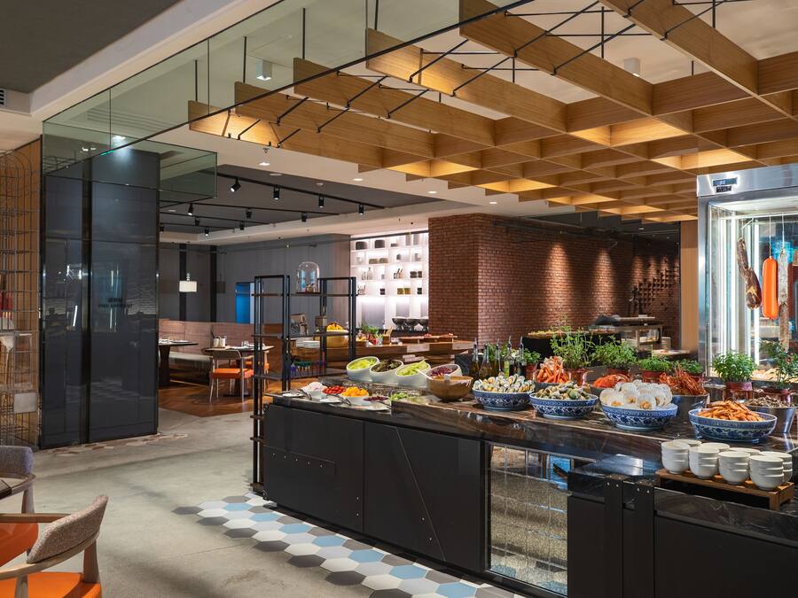 Un restaurante moderno con barra libre, que ofrece una variedad de platos y un fondo de pared de ladrillo.