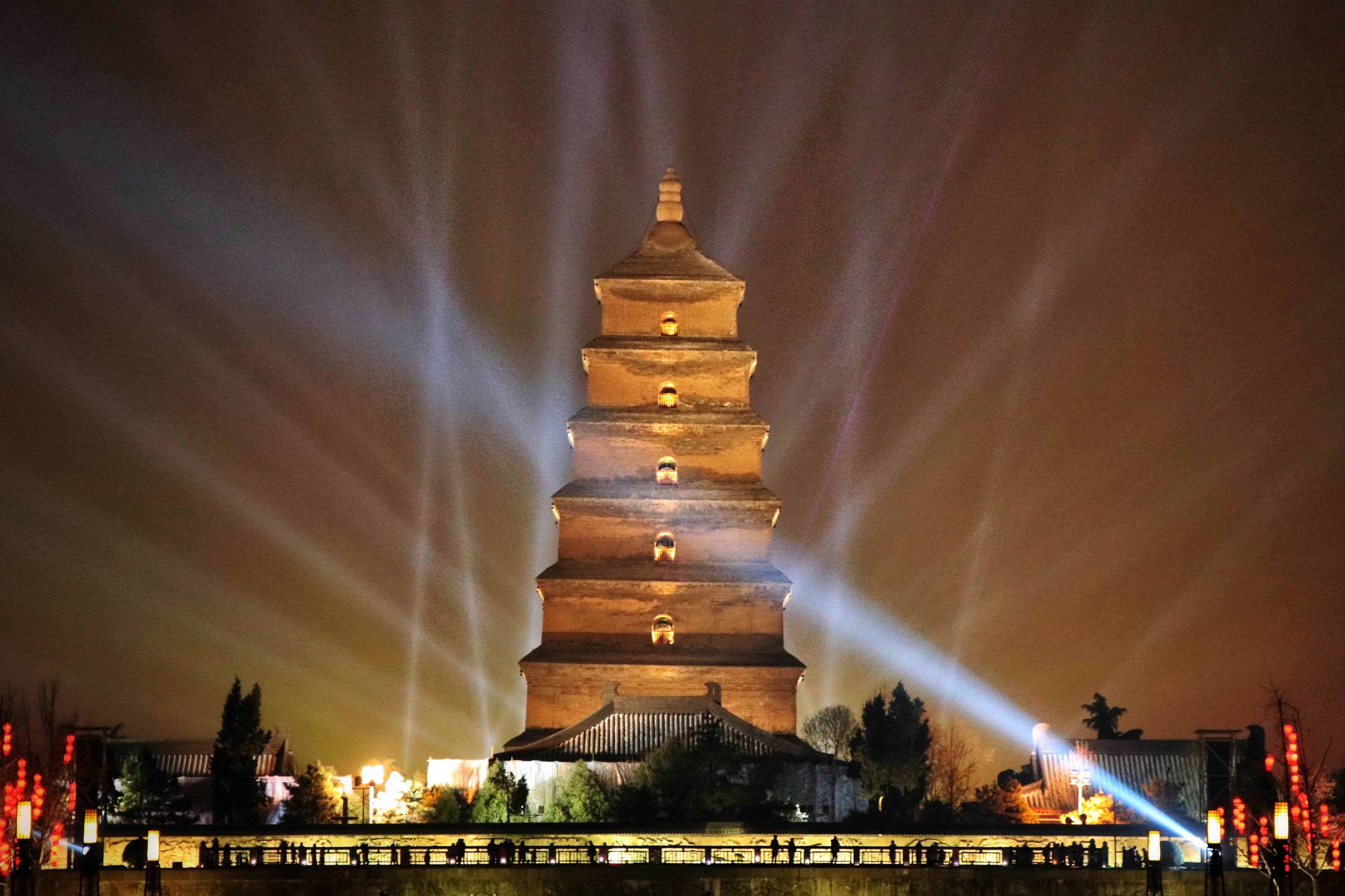 A multi-tiered pagoda illuminated by spotlights at night.
