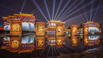 A traditional Chinese pavilion with ornate decorations and a reflection in the water.