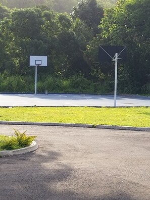 Uma quadra de basquete com uma cesta e uma estrutura de painel solar.