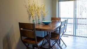 A dining area with a wooden table, four chairs, and a ceiling fan. - Lyndale House: Full house with 3 br (Corning)