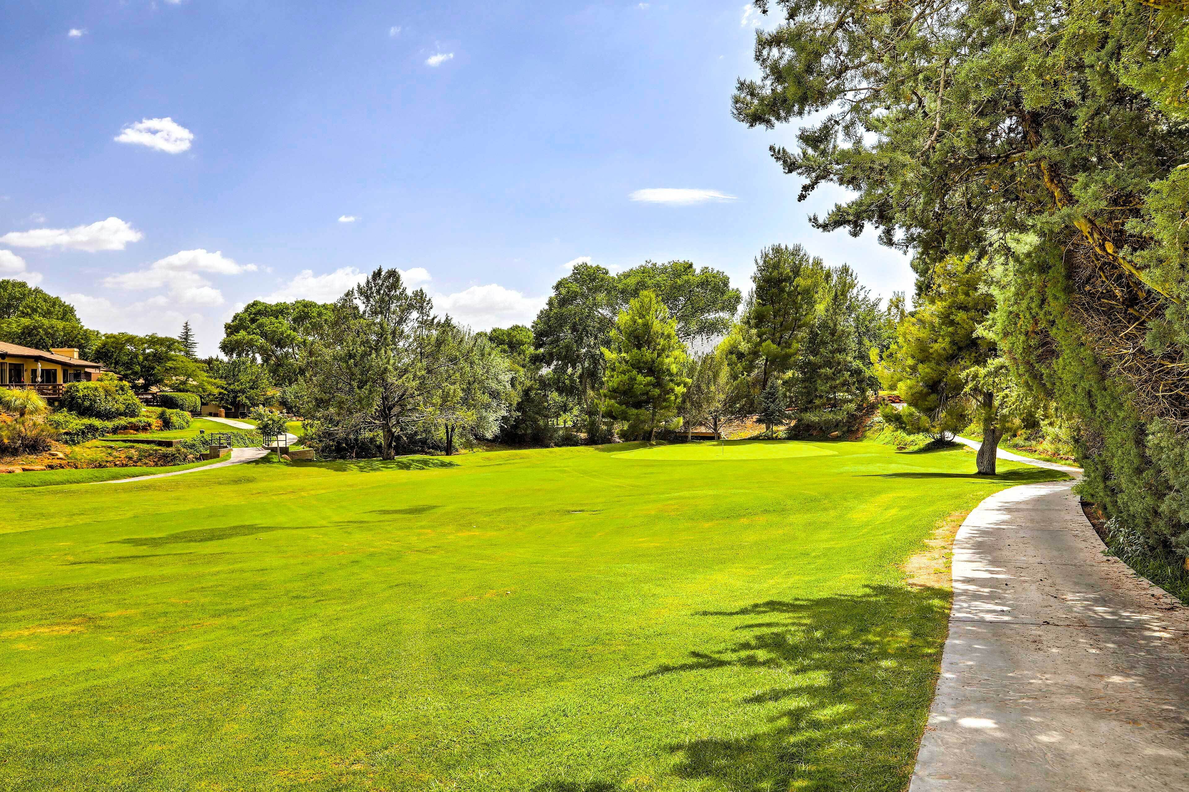 Un parcours de golf bien entretenu, doté d’un chemin clairement délimité et entouré d’une végétation luxuriante et d’arbres.