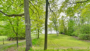 Puisto, jossa on kyltti, jossa lukee ”JÄRVI”, ja polku, joka johtaa vesistöön.