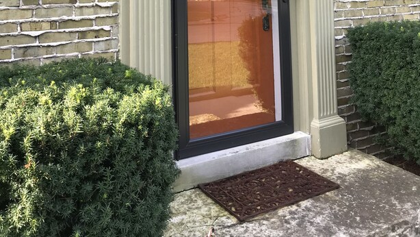A building with a brick facade, a door with a wreath, and a number plaque reading "1810".