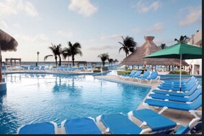 Una piscina al aire libre, sombrillas