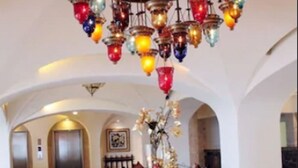 A spacious lobby with a large, ornate chandelier, a plush sofa with patterned cushions, and a vase of flowers on a table. - Club GR Caribe Cancun – Premier All Inclusive (Cancun)