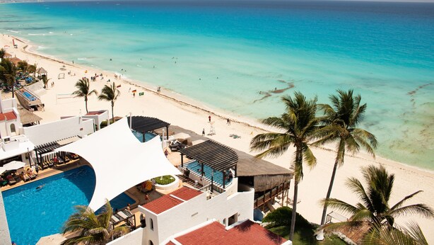 A resort with a pool, beach, and palm trees. - Club GR Caribe Cancun – Premier All Inclusive (Cancun)