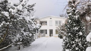 A snow-covered house with a front door, windows, and a driveway. - Apartment Gording II - Holiday residence sea desire (Koserow)