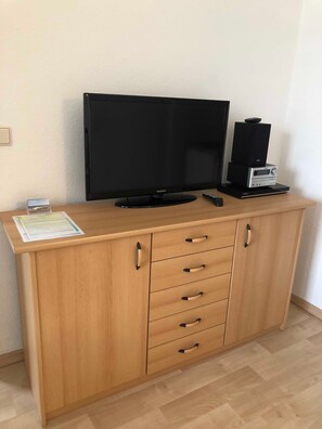 Un meuble en bois contenant un téléviseur à écran plat et un système audio.