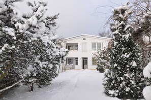 A snow-covered house with a front door, windows, and a driveway. - Apartment Gording II - Holiday residence sea desire (Koserow)