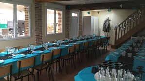 Una larga mesa de comedor con sillas, una escalera y vistas al exterior.