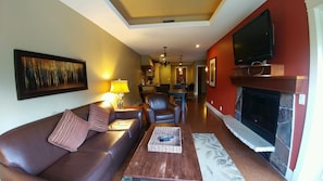 Relax in this stylish living room with a comfortable sofa, flat-screen TV, and fireplace.