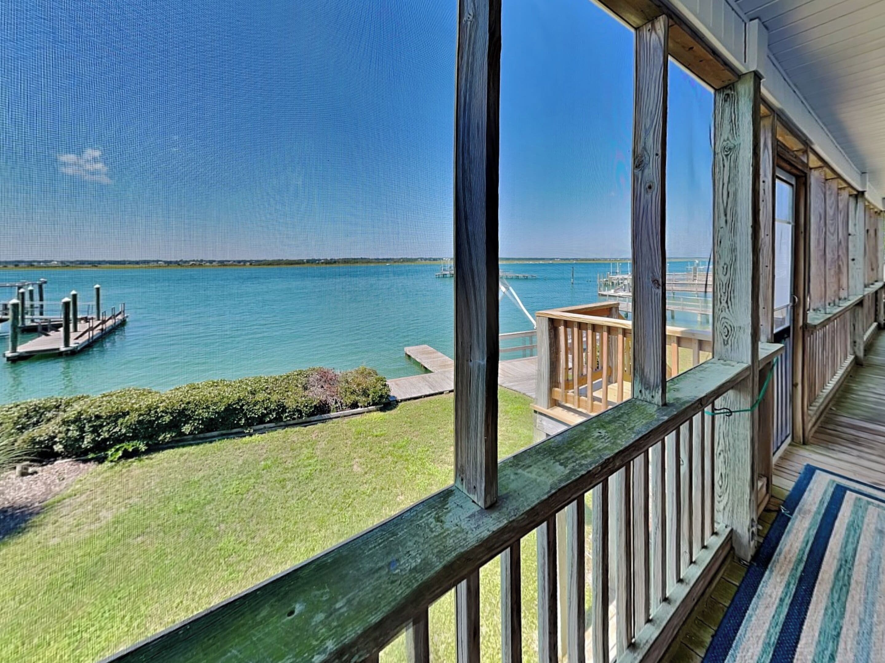 A view from a balcony overlooking a marina with docks and a clear blue sky.