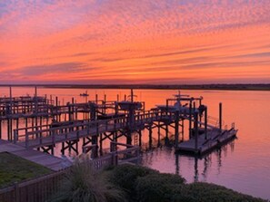 A waterfront dock with multiple piers extending into calm water during sunset. - Lindy-B | Sound Views + Screened Porch! (Topsail Beach)