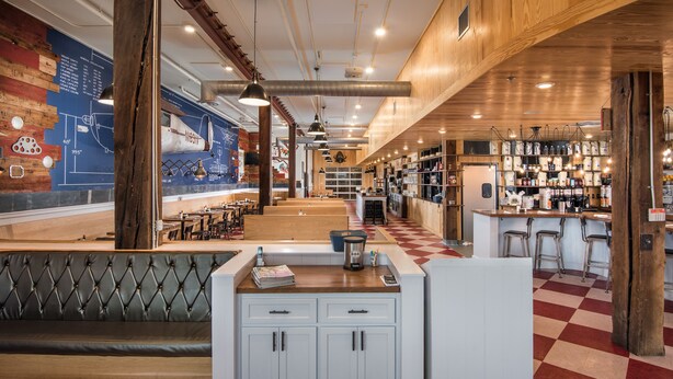 A restaurant interior with a bar area, seating, and a counter with a coffee machine. - The Stricklin Hotel (Florence)