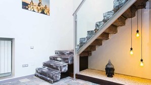 A staircase with stone steps, a Buddha statue, and hanging light bulbs. - 4 Rooms Barcelona (Barcelona)