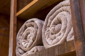A wooden shelf with neatly rolled towels. - Guarany Eco Resort (Monte Sião)