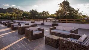 Una terrazza sul tetto con mobili in vimini e un pavimento in legno.
