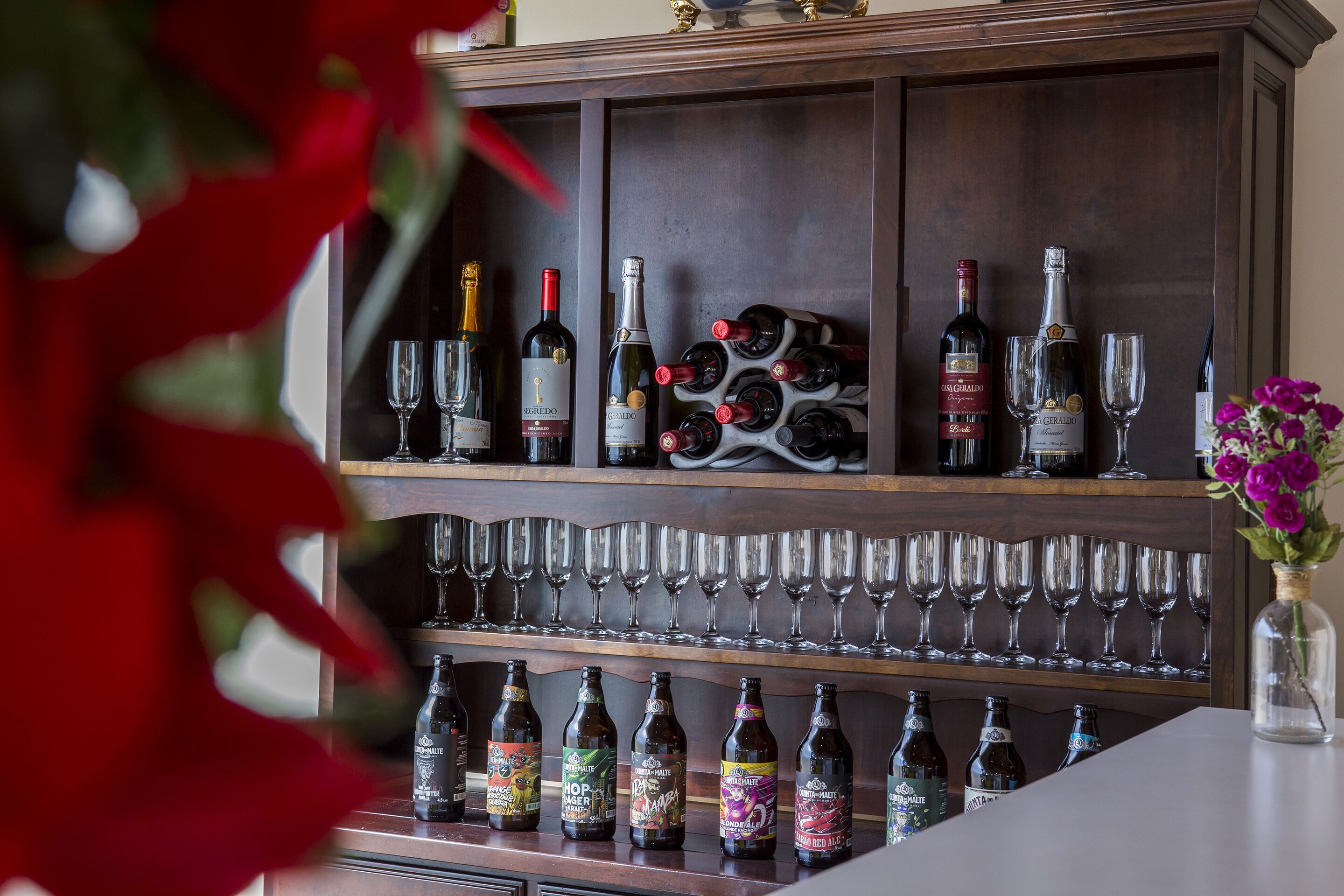 A bar area with wine bottles and glasses.