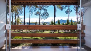 Una panchina di legno con vista su un giardino curato e montagne in lontananza.