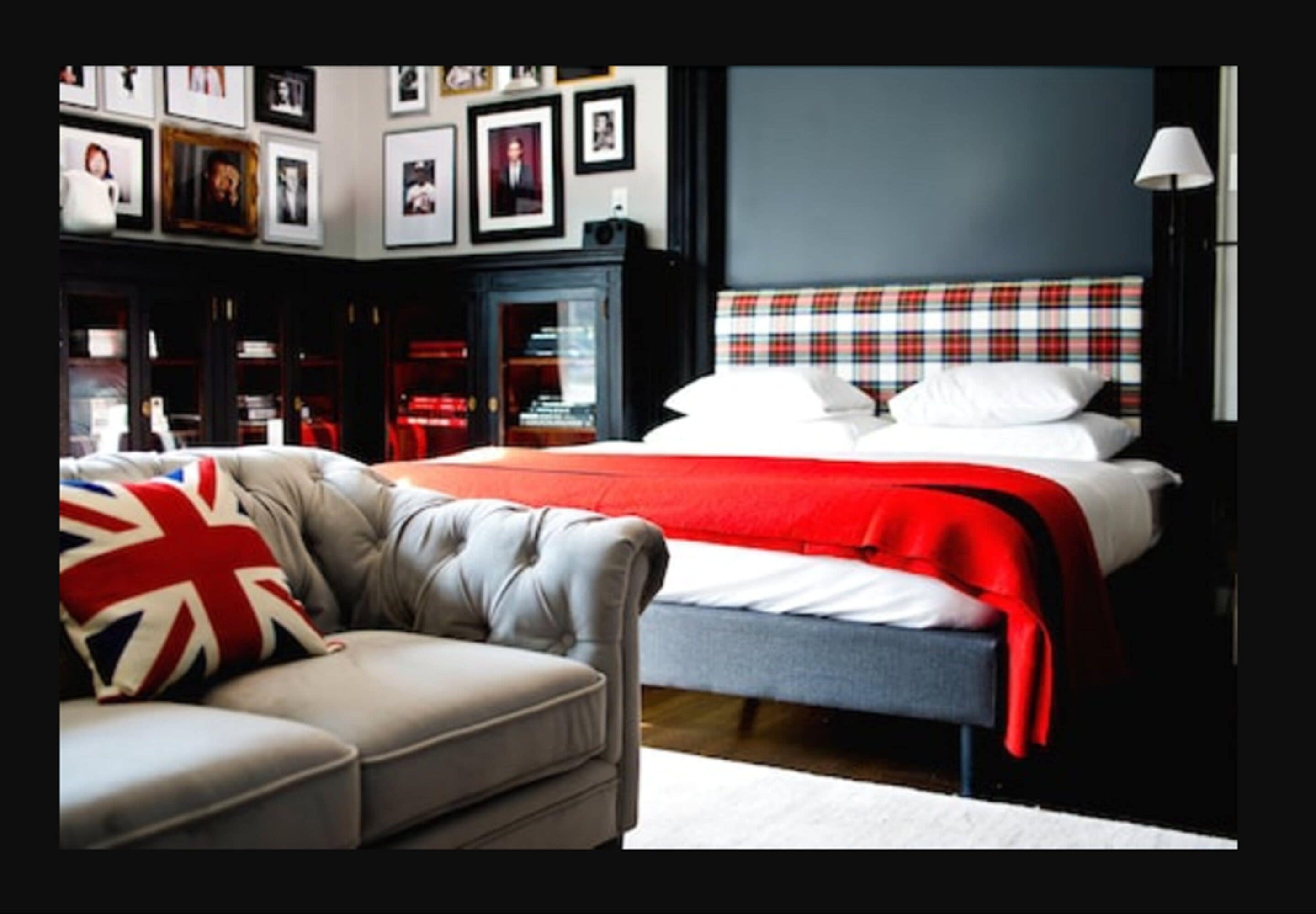 A bedroom with a bed, a sofa, and a fireplace.