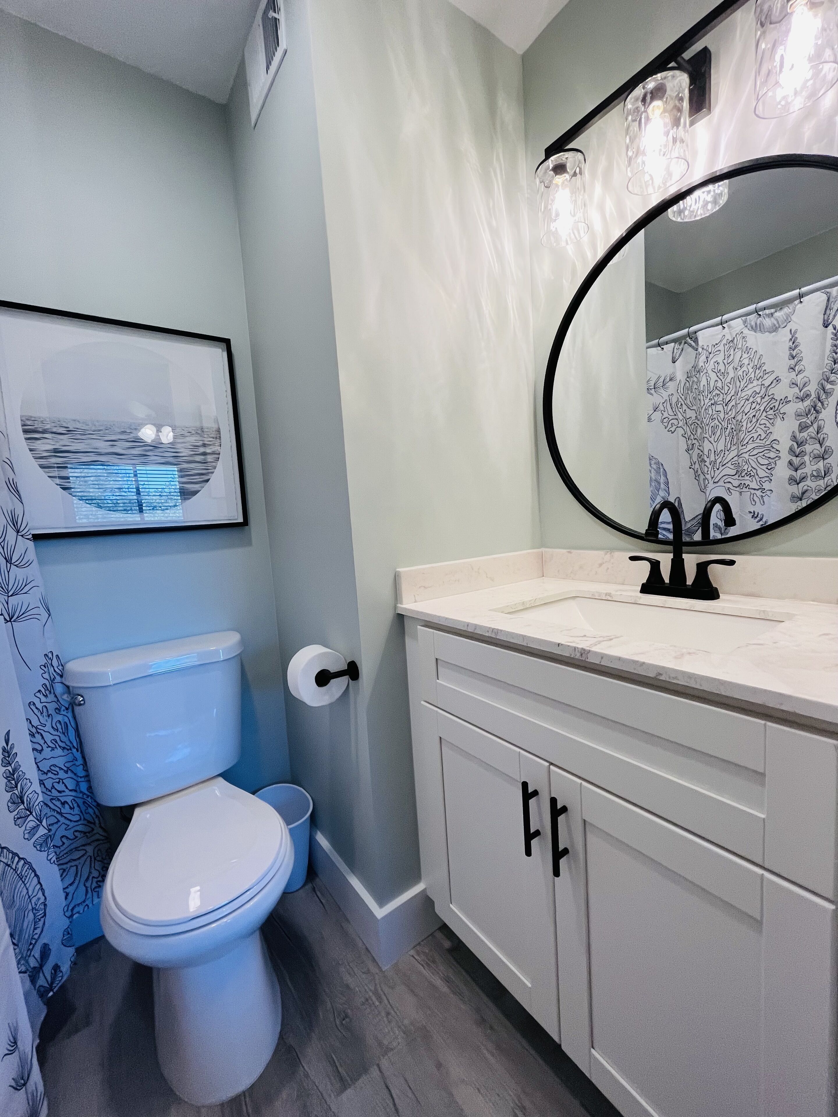 Un baño con inodoro, lavamanos y espejo.