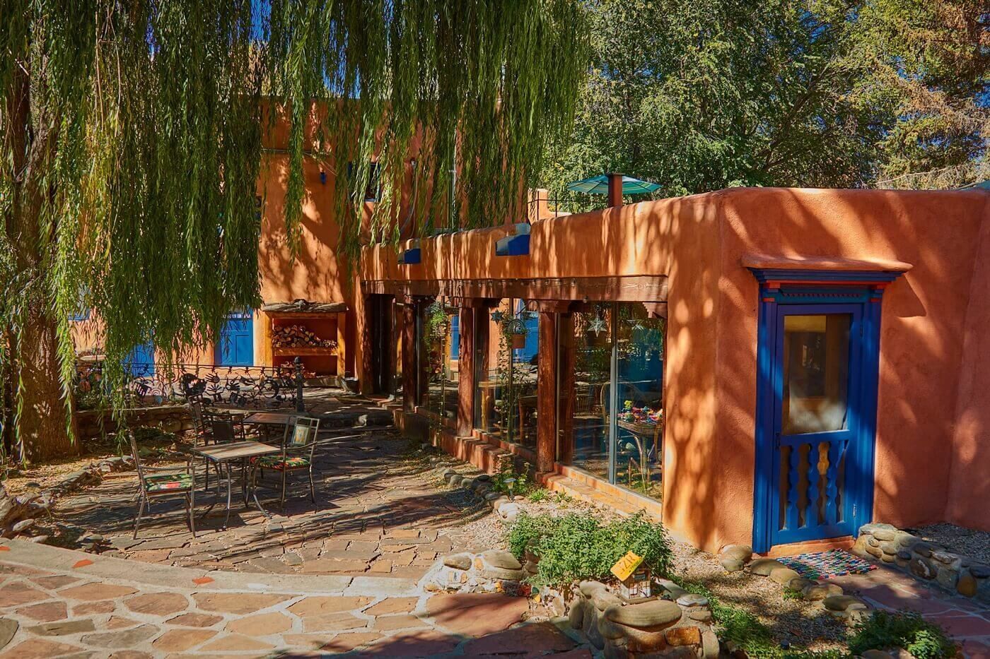 A rustic outdoor seating area with stone flooring and a small garden.