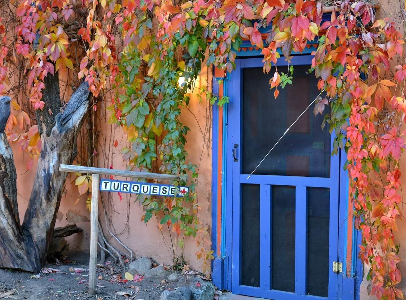A building with a blue door and a sign that reads "TURQUESE".