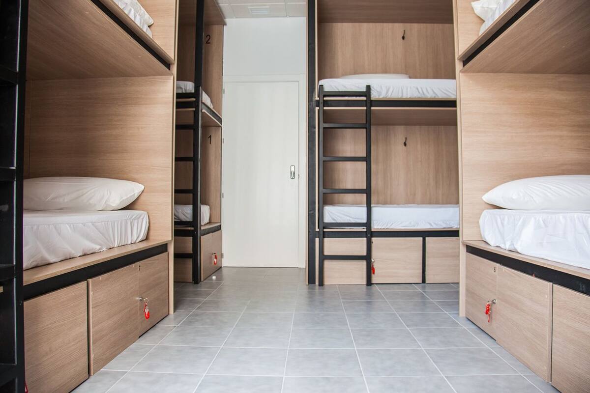 A room with bunk beds, a door, and a tiled floor.