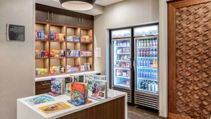 A children's book display area with a refrigerator stocked with beverages.