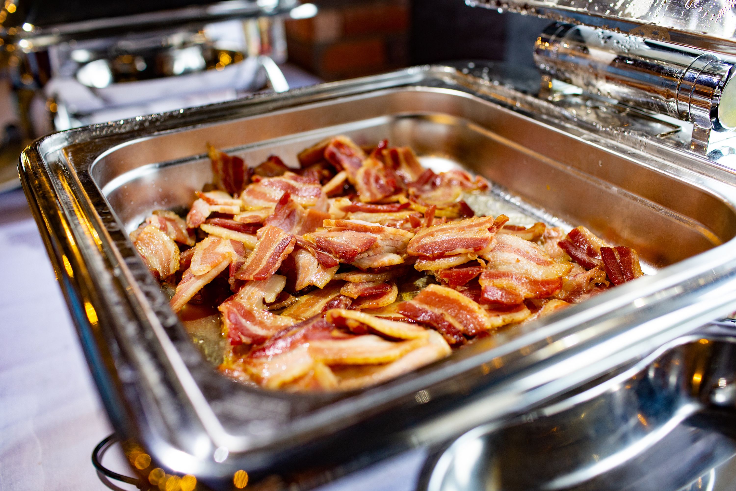 A buffet with a variety of food items, including bacon and other dishes.