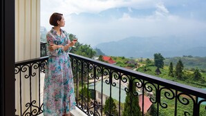 A person on a balcony with a view of a mountainous landscape. - The View Sapa Hotel (Sa Pa)