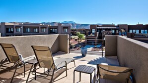 Terraza en la azotea con mobiliario exterior y vista a la piscina.