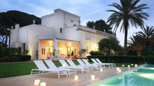 Un espace aménagé au bord de la piscine, avec des chaises longues et des bougies.