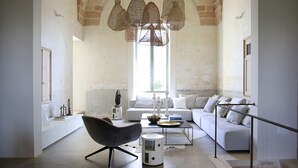 Un salon spacieux doté d’un haut plafond en arc de cercle, d’un fauteuil moderne, d’un canapé et d’une table basse.