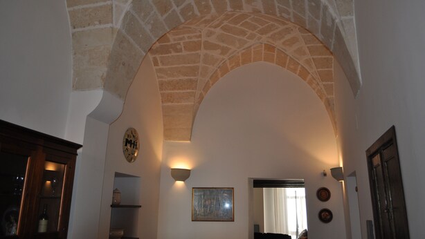 An arched stone ceiling with a clock and wall-mounted lights. - Beautiful, romantic and central (Lecce)