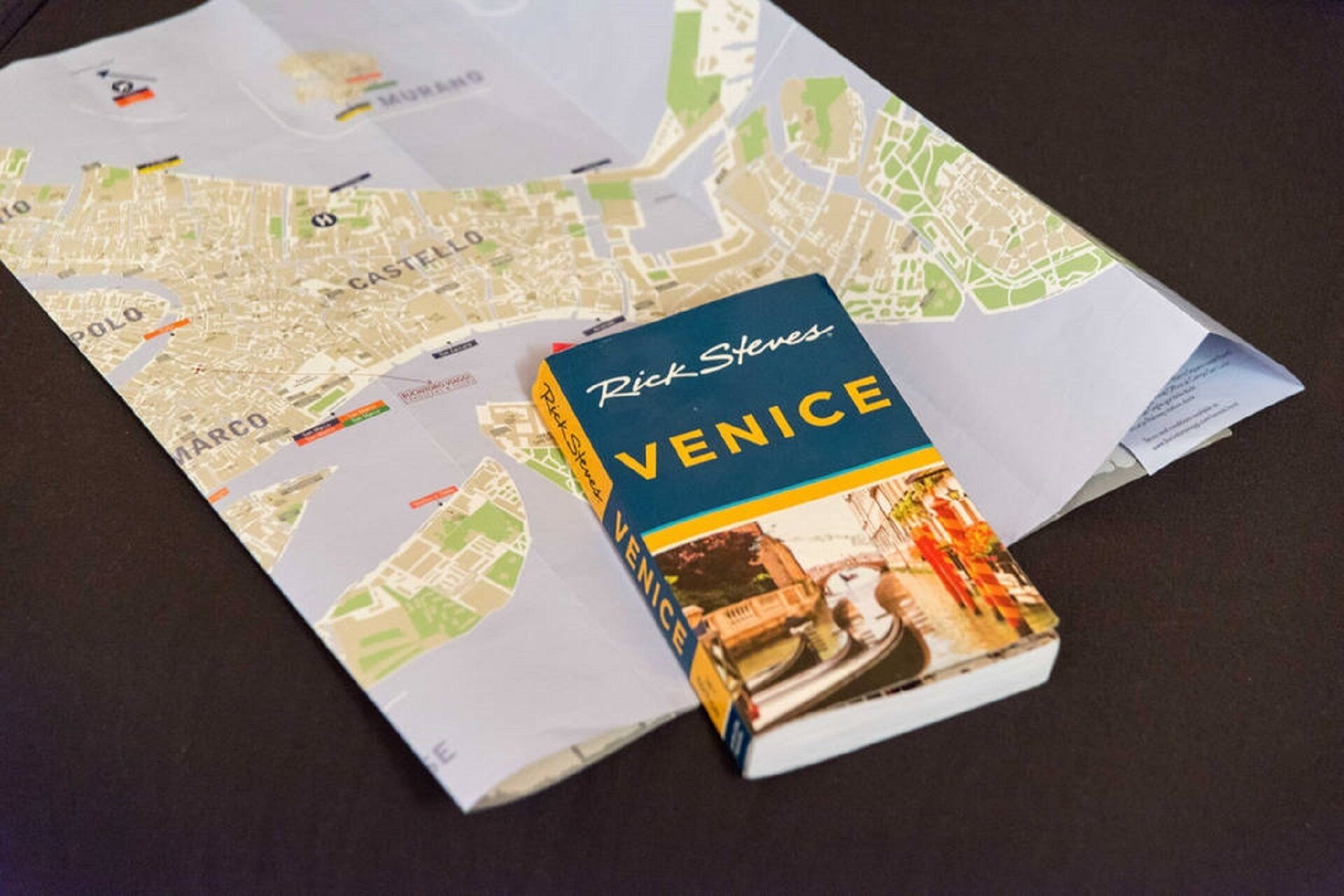 A book titled 'Rick Steves Venice' placed on a map.