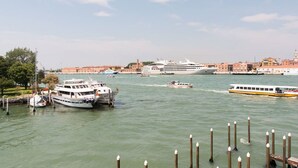 Un canal où étaient amarrés des bateaux, dont un navire de croisière et d’autres embarcations plus petites, le long du quai.