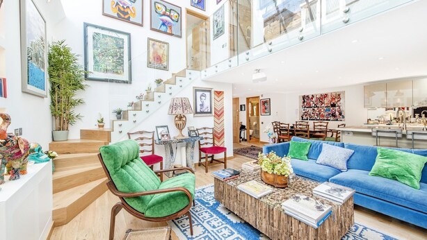A spacious living room with a staircase, a dining area, and a kitchen. - Chelsea Artist's Studio, by Veeve (London)