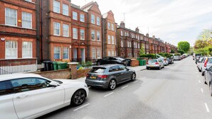 A row of red brick terraced houses with parked cars on the street. - Contemporary in Swiss Cottage, by Veeve (London)