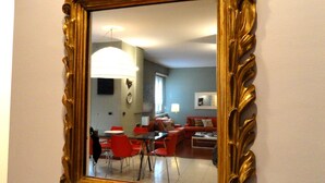 A room with a dining area, red chairs, a table, and a red sofa.