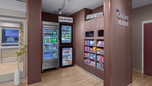 Una tienda de barrio con una vitrina refrigerada y un área de almacenamiento.