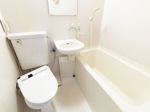 A small, clean bathroom with a toilet, sink, and bathtub. - Business Hotel Apple (Nagoya)