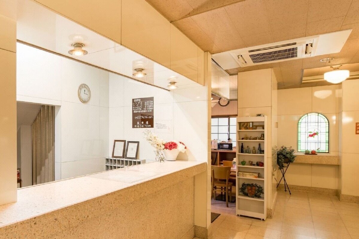 A reception area with a counter, a clock, a bulletin board, and a window with a view.