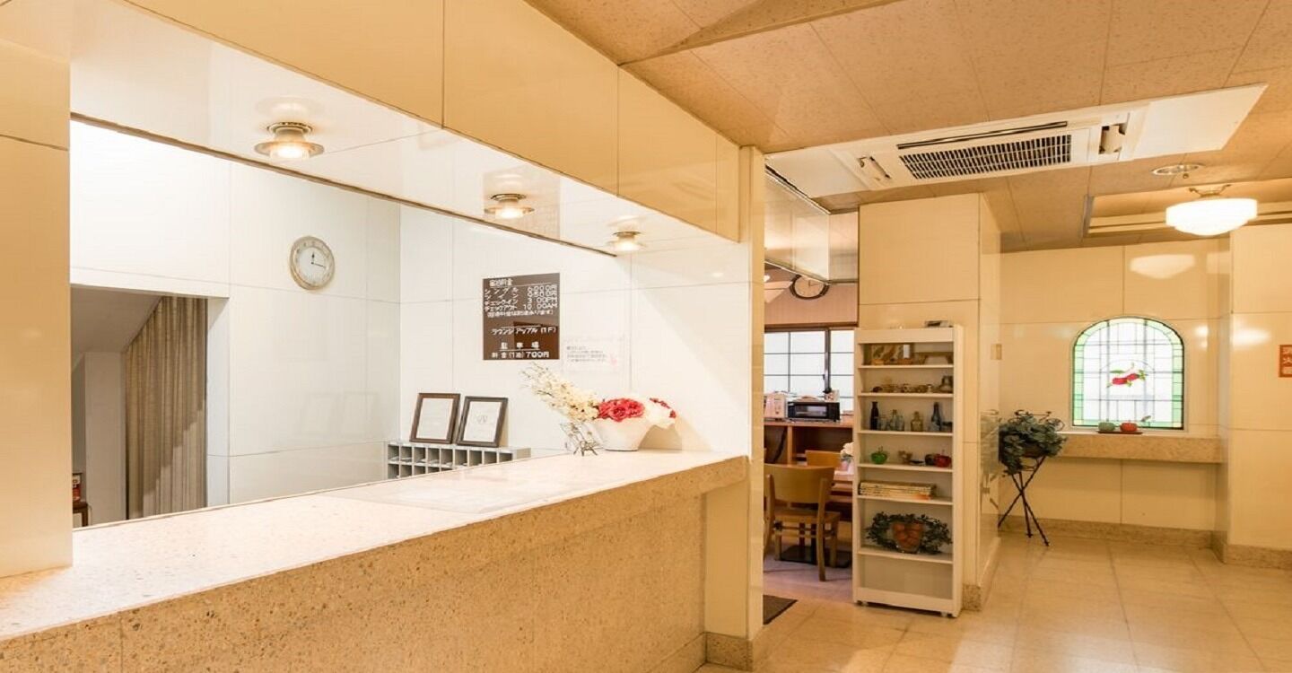 A reception area with a counter, a clock, a bulletin board, and a window with a view.