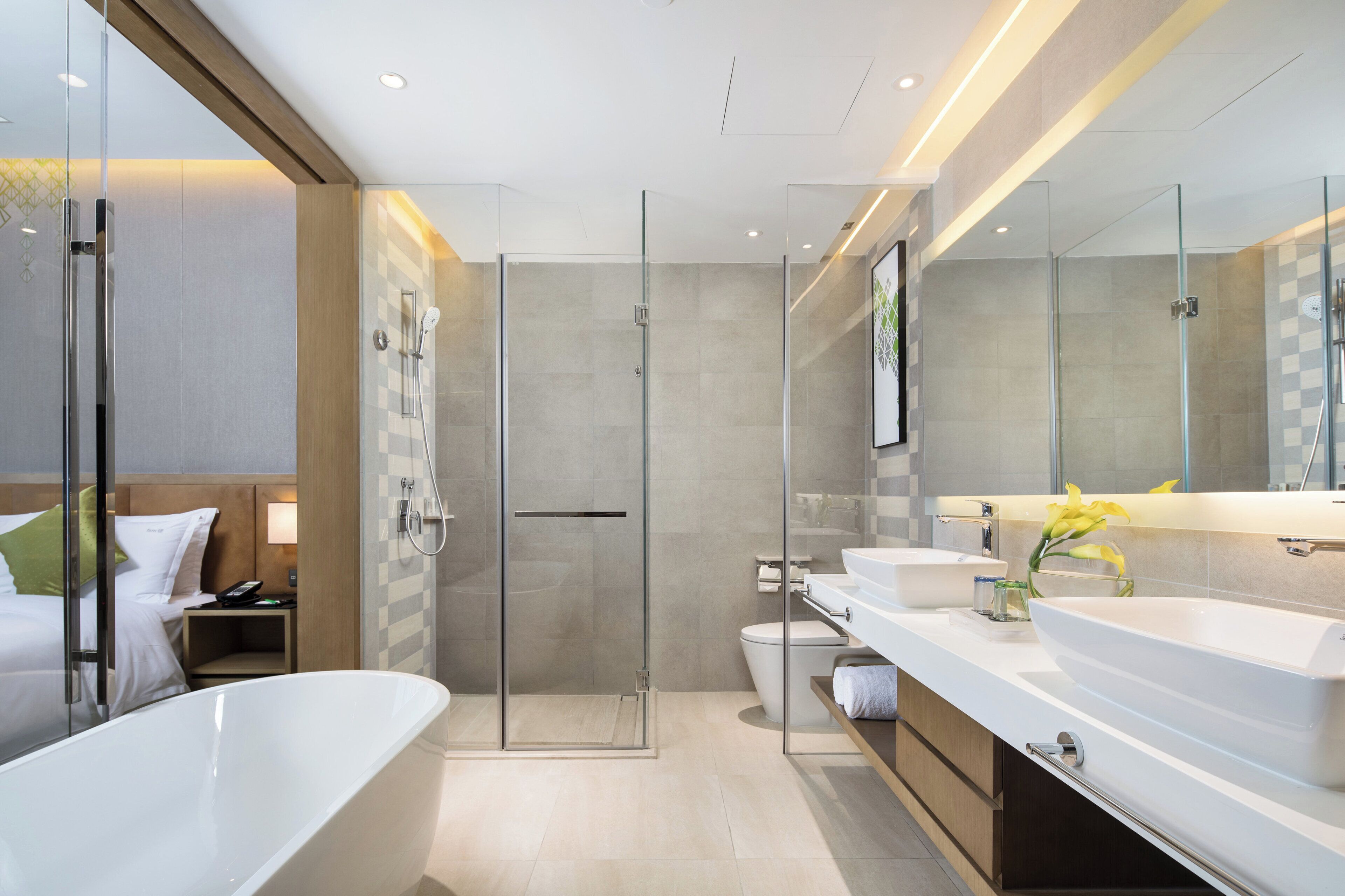 Une salle de bain moderne dotée d’une douche à parois de verre, d’une baignoire sur pieds et d’un meuble-lavabo avec deux vasques.