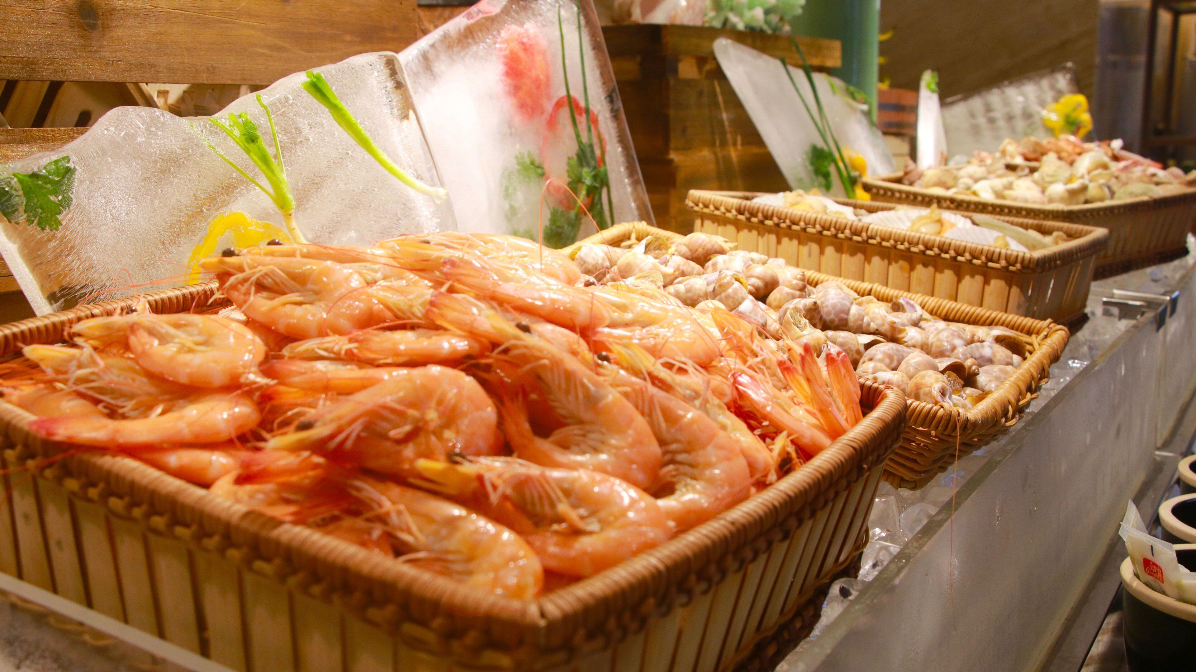 Un présentoir de produits de la mer avec des paniers de crevettes et d’autres articles.