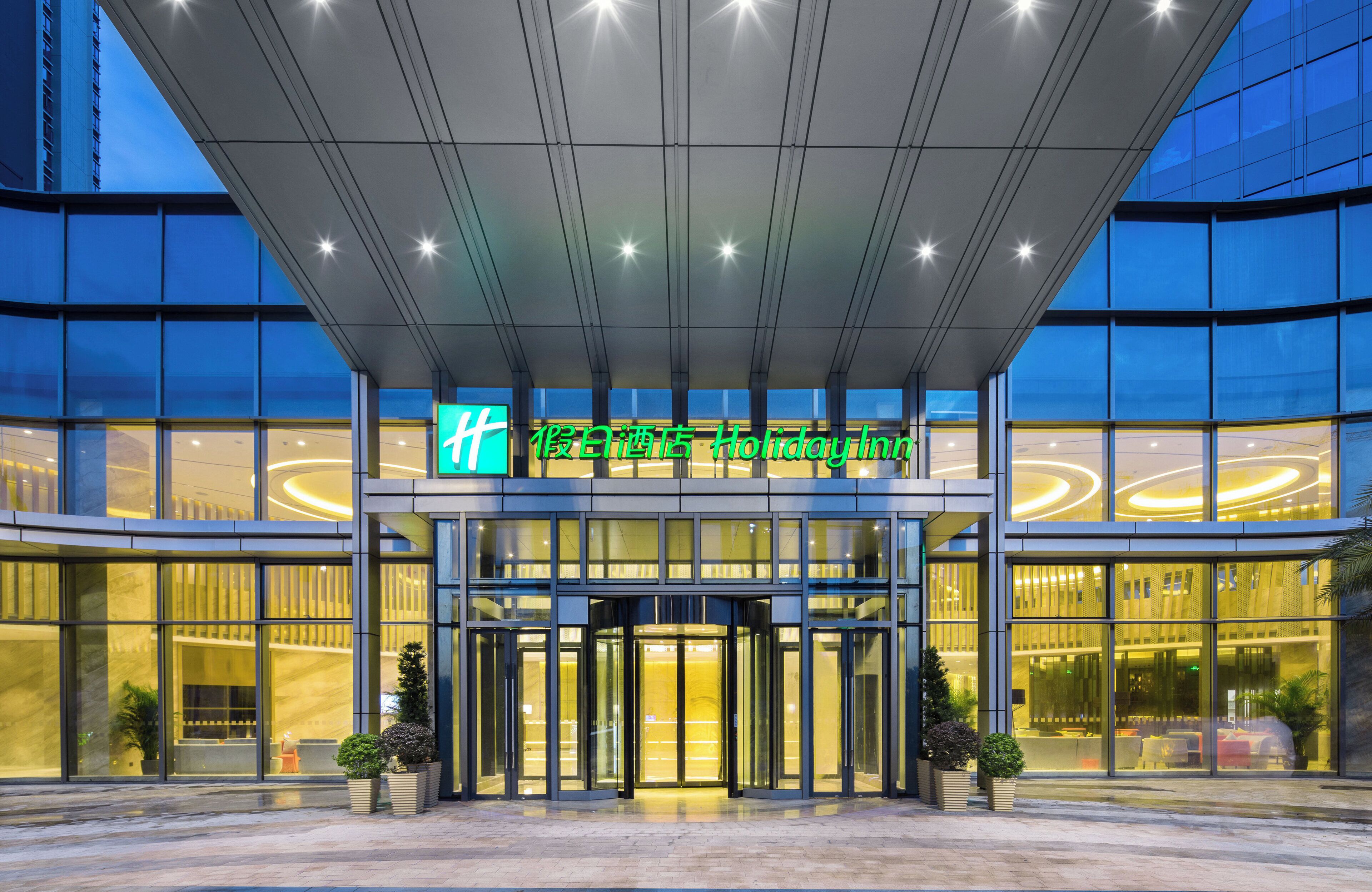Entrada d'hotel amb un disseny modern, amb façana de vidre i un rètol destacat sobre les portes.