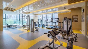 A modern gym with various exercise equipment, large windows, and a bright interior. - Holiday Inn Shaoguan Downtown by IHG (Shaoguan)